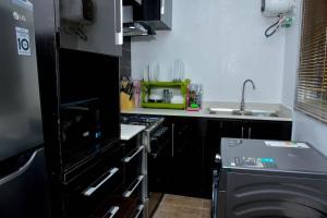 a kitchen with a stove top oven next to a sink at Tiyani Court in Lagos