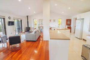 a large kitchen and living room with wooden floors at Stunning Home in Mt Mellum with Panoramic Coastal Views in Bald Knob
