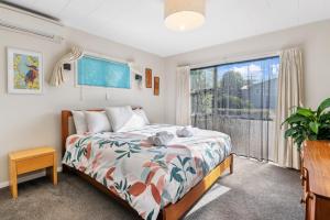a bedroom with a bed and a large window at Rooftops Rotorua in Rotorua