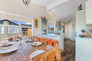 a kitchen and dining room with a table with wine glasses at Rooftops Rotorua in Rotorua