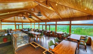 a restaurant with wooden tables and chairs and windows at The Walnut Creek Pahalgam in Pahalgām