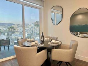 a dining room with a table and chairs and a mirror at New Designer Corner Penthouse 2 Bedroom w/ 3 Beds in Los Angeles