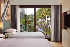 塞米亚克Courtyard by Marriott Bali Seminyak Resort的有两张床和一扇大窗户的酒店房间