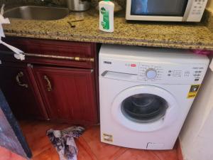 a kitchen with a washing machine under a counter at Porto marina in El Alamein