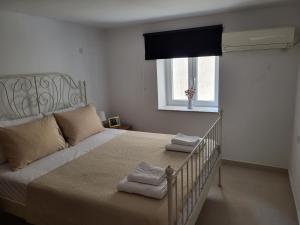 um quarto com uma cama com duas toalhas em Lion's House em Calímnos
