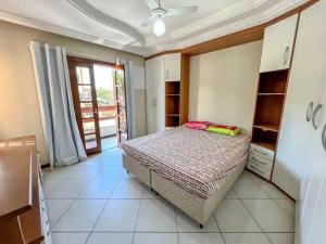 um quarto com uma cama num quarto com uma janela em Casa Paris 481 - Sua Mansão na Praia do Morro em Guarapari