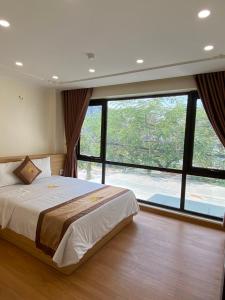 a bedroom with a large bed and a large window at Đức Khôi Hotel in Cao Bằng