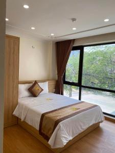 1 dormitorio con 1 cama grande y ventana grande en Đức Khôi Hotel, en Cao Bằng