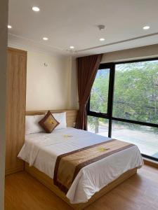 a bedroom with a large bed with a large window at Đức Khôi Hotel in Cao Bằng