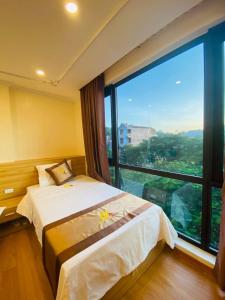 a hotel room with a bed and a large window at Đức Khôi Hotel in Cao Bằng