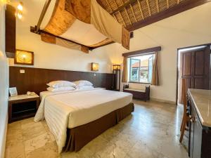 a bedroom with a large bed in a room at The Lagoon Bali Pool Hotel and Suites in Legian