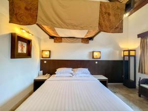 a bedroom with a large white bed in a room at The Lagoon Bali Pool Hotel and Suites in Legian