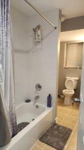 a bathroom with a bath tub and a toilet at Cozy King Bed, Free Parking! in Newark