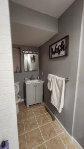 a bathroom with a sink and a toilet and a mirror at Cozy King Bed, Free Parking! in Newark