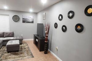 uma sala de estar com um sofá e relógios na parede em Cozy King Bed, Free Parking! em Newark