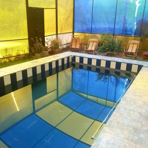 una piscina con azulejos azules en el suelo en Hermosa casa de campo, en Maras