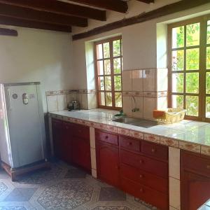 een keuken met een wastafel en een koelkast bij Hermosa casa de campo in Maras