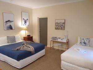 a hotel room with two beds and a desk at The Lancefield Lodge in Lance Field