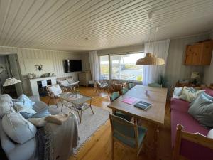 ein Wohnzimmer mit einem Sofa und einem Tisch in der Unterkunft Fantastisk sjøhytte, 10 sengeplasser, strand og egen brygge in Fredrikstad