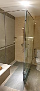 a bathroom with a shower and a toilet and a sink at Nikko Hotel - The Classy Life in Ho Chi Minh City