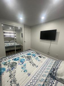 1 dormitorio con 1 cama y TV en la pared en Triple M Lodge Double, en Mississauga