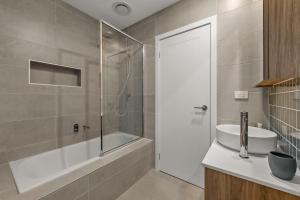 a bathroom with a tub and a sink and a shower at StayCentral - Brunswick Central Townhouse in Melbourne +33 photos