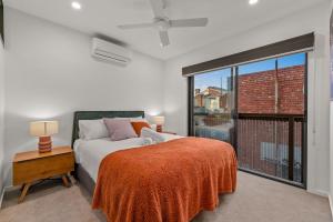 a bedroom with a bed and a large window at StayCentral - Brunswick Central Townhouse in Melbourne
