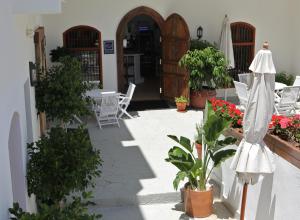 a patio with chairs and an umbrella and plants at Santuario San José in San José