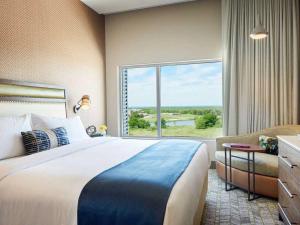 a hotel room with a large bed and a large window at The Stella Hotel, Autograph Collection in Bryan