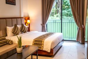 Habitación de hotel con cama y sofá en Marvelinn Siem Reap, en Siem Reap