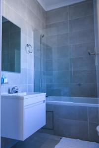 a bathroom with a sink and a shower and a tub at Sarona City Studio L303 in Gaborone