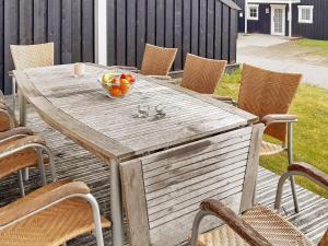 a wooden table with a bowl of fruit on a patio at 8 person holiday home in Gjern in Gjern