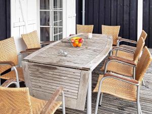 einen Holztisch mit einer Obstschale auf einer Terrasse in der Unterkunft 8 person holiday home in Gjern in Gjern