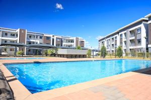 a large swimming pool in front of a building at Sarona City Alpha Apartment L303 in Gaborone