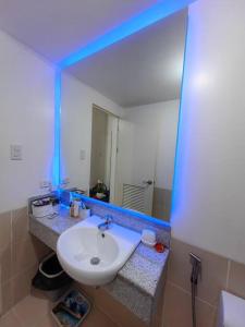 a bathroom with a white sink and a mirror at Infina Towers Cozy 2bedroom Condo in Manila
