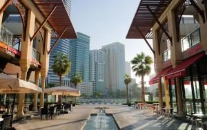 a city street with tables and chairs and buildings at Happy nights in Sharjah