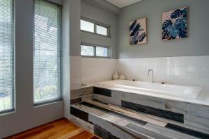 a bathroom with a large white tub and windows at Mahree I Private Properties in Yallingup