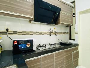 een keuken met een magnetron en een fornuis bij Cozy 1-10 pax 4QBeds 2SBeds Shah Alam Sec7, I-city in Shah Alam