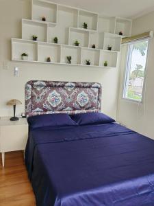 a bedroom with a bed with purple sheets and a window at Casa Felicitas 1 in Davao City
