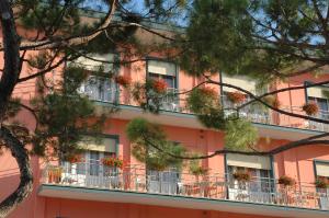 un edificio rosa con macetas en los balcones en Hotel Moderno, en Lido di Jesolo