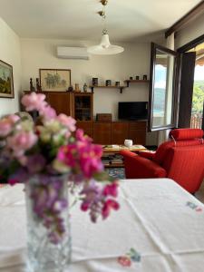 eine Vase mit rosa Blumen auf einem Tisch in der Unterkunft Appartamento CASA DEI NONNI 