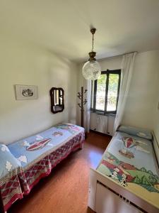 1 Schlafzimmer mit 2 Betten und einem Kronleuchter in der Unterkunft Appartamento CASA DEI NONNI 