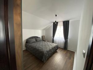 Schlafzimmer mit einem Bett und einem Fenster in der Unterkunft Casa Villa in Oradea