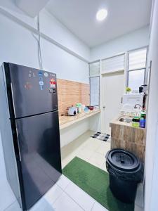 uma cozinha com um frigorífico e um tapete verde em HR HOMESTAY WAKAF CHE YEH KOTA BHARU KELANTAN em Kota Bharu