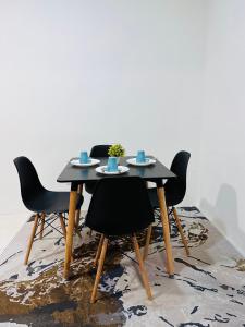 uma mesa preta com quatro cadeiras num tapete em HR HOMESTAY WAKAF CHE YEH KOTA BHARU KELANTAN em Kota Bharu