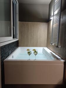 SOHO B&B في فيشانو: حوض الاستحمام مع اثنين من كؤوس النبيذ يجلس عليه