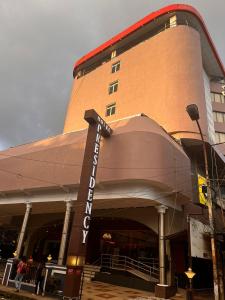 un edificio con una señal de hotel delante de él en Hotel Presidency, en Kochi