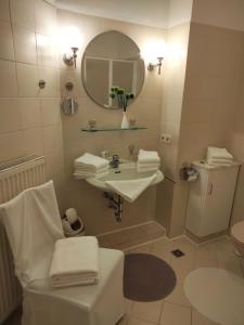 a white bathroom with a sink and a mirror at Ferienwohnung Benvenuto in Bad Harzburg +26 photos