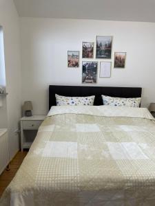 a bedroom with a large white bed with pictures on the wall at Appartement zur Wied in Oberlahr