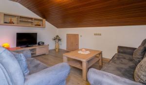 ein Wohnzimmer mit einem Sofa und einem Tisch in der Unterkunft Ferienwohnungen Gstöttner in Bodenmais